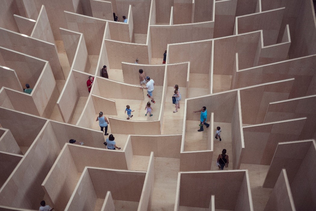 A walkable maze with people navigating through it. 