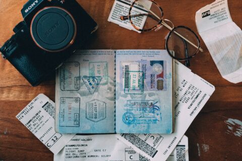 A table with a passport, camera, and stubs of boarding passes and other travel documents.
